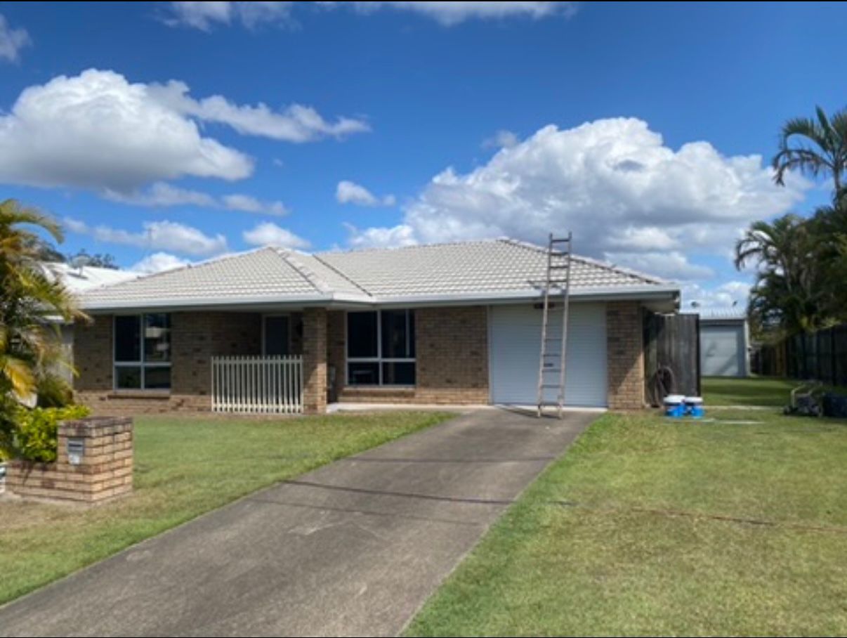 Brick house featuring a freshly painted light grey tile roof following a complete roof restoration